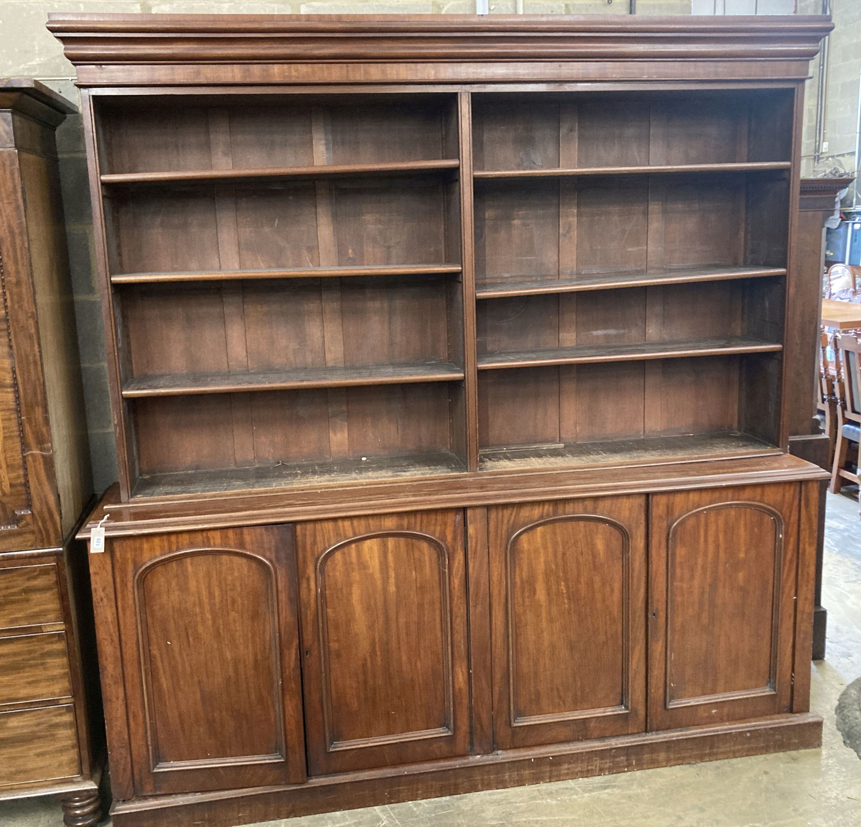 A Victorian mahogany library bookcase, the open shelves over an enclosed four door base, length 230cm, depth 50cm, height 238cm